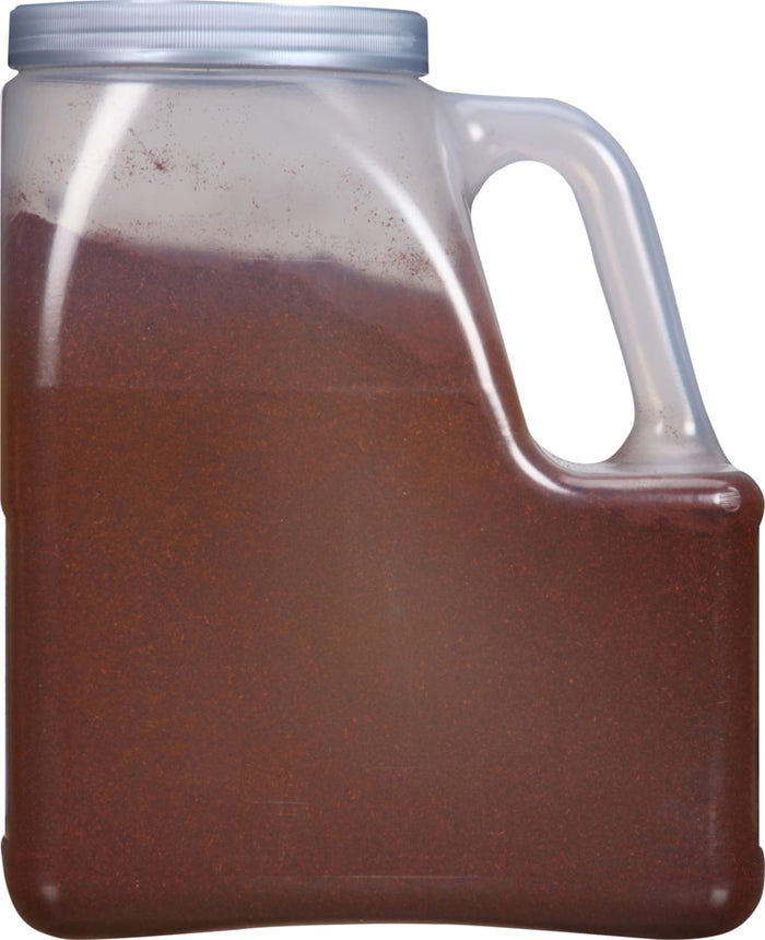 A clear plastic jar with a handle filled with a red powder.