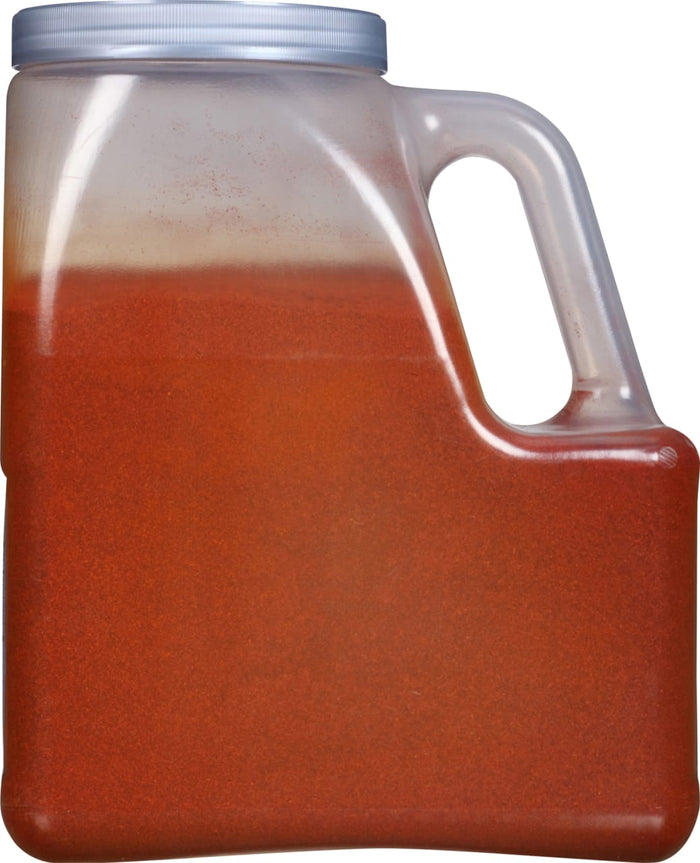 A clear plastic jug filled with red chili powder.