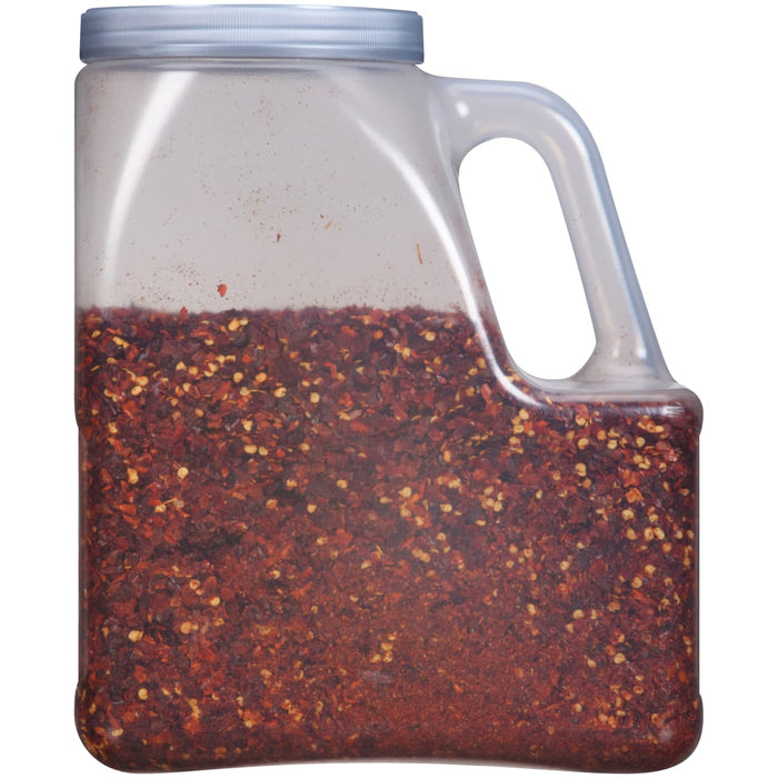 A plastic jar filled with red pepper flakes.