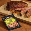 A juicy grilled steak seasoned with McCormick Grill Mates Baja Citrus seasoning is displayed on a wooden cutting board.