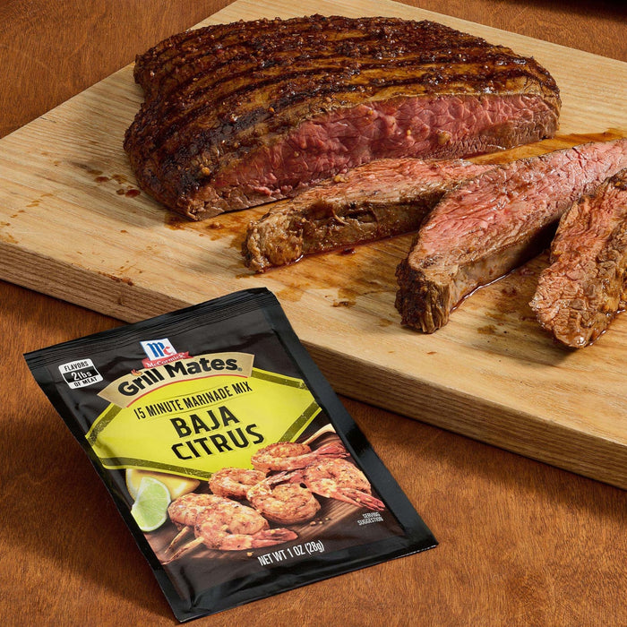 A juicy grilled steak seasoned with McCormick Grill Mates Baja Citrus seasoning is displayed on a wooden cutting board.