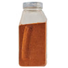 A clear plastic bottle filled with a red-brown spice.