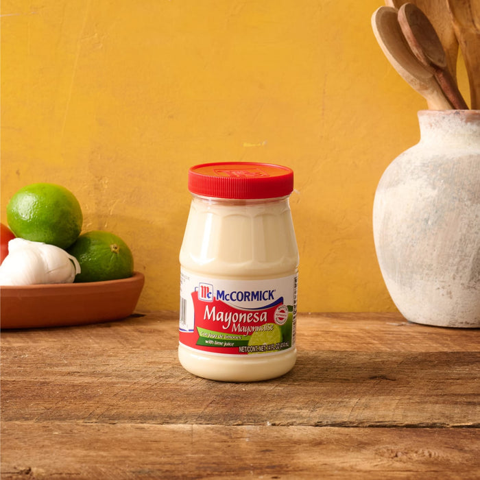 A jar of McCormick Mayonesa Mayonnaise with limes and garlic in the background.