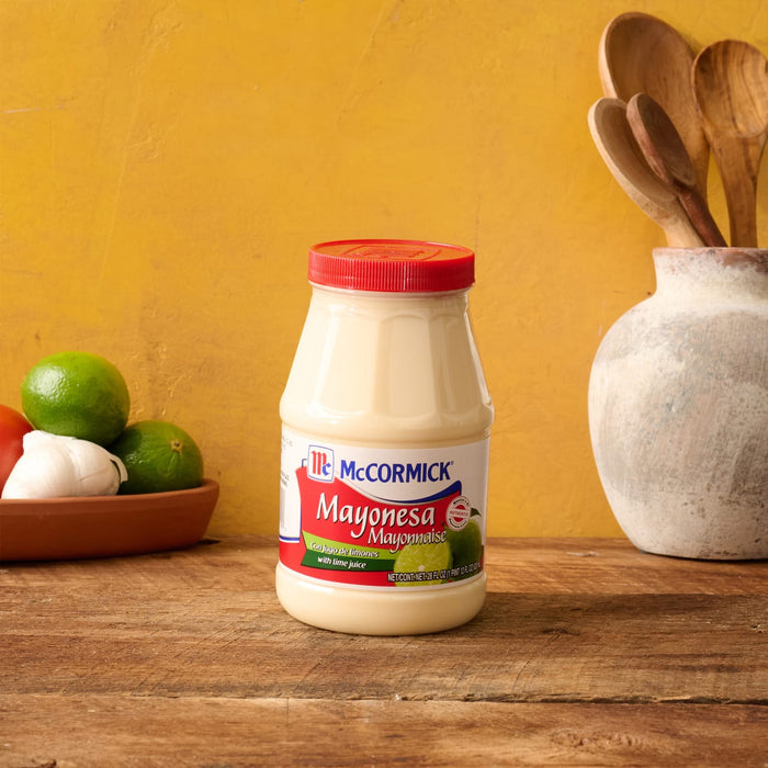 A jar of McCormick Mayonesa Mayonnaise with limes and garlic in the background.