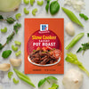 McCormick Slow Cooker Savory Pot Roast seasoning packet surrounded by fresh vegetables.