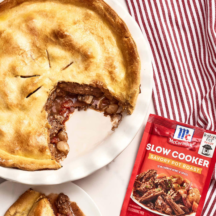 A close-up of a pot pie with a side of McCormick Slow Cooker Savory Pot Roast seasoning mix.