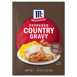 A package of Mccormick Peppered Gravy Mix Country 2.64 Oz is shown in front of a serving suggestion of the prepared gravy over biscuits, eggs, and bacon.