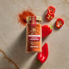 A glass jar of Mccormick Gourmet Smoked Paprika Organic 1.62 Oz sits on a light marble surface, surrounded by spilled paprika powder and fresh red mini bell peppers, some whole and some sliced