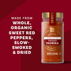 A jar of Mccormick Gourmet Smoked Paprika Organic 1.62 Oz is displayed on a red background, with text emphasizing it is made from whole, organic sweet red peppers, slow-smoked and dried.