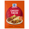 McCormick Cheesy Taco Seasoning Mix package with a serving suggestion of two tacos on a white plate.
