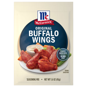 A packet of Mccormick Original Buffalo Wing Seasoning Mix 1.6 Oz featuring a plate of spicy glazed chicken wings served with celery sticks and dipping sauce.