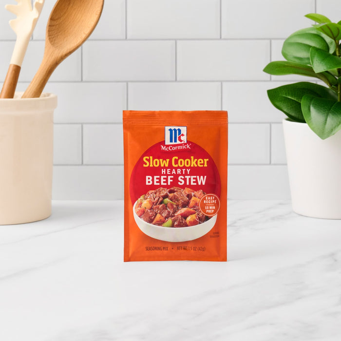 A packet of McCormick Slow Cookers Beef Stew seasoning mix sits on a countertop.