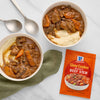 Two bowls of beef stew with mashed potatoes and a packet of McCormick Slow Cooker Beef Stew seasoning.