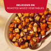A white serving dish is filled with roasted mixed vegetables, including potatoes, carrots, and red onions, seasoned with Mccormick Toasted Onion And Garlic Seasoning Mix 1.25 Oz.
