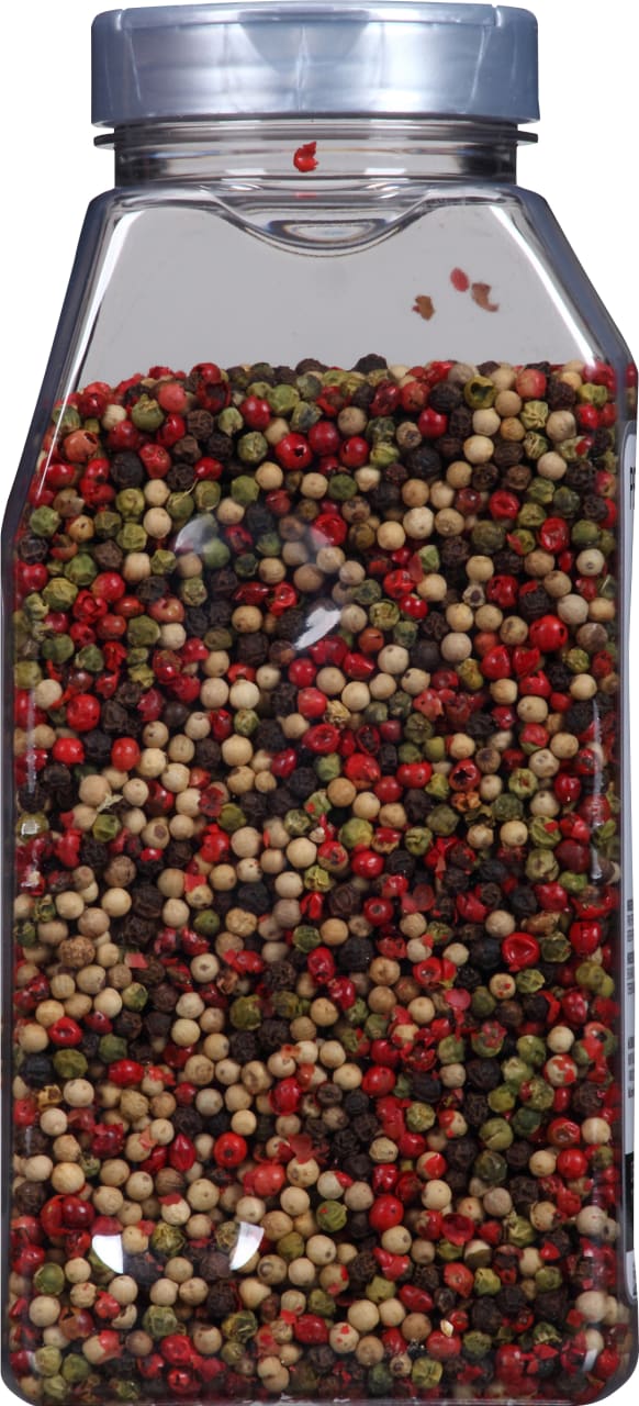 A glass jar filled with a mix of black white green and red peppercorns.