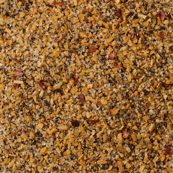 A close-up of a blend of spices including salt pepper garlic and red pepper flakes.