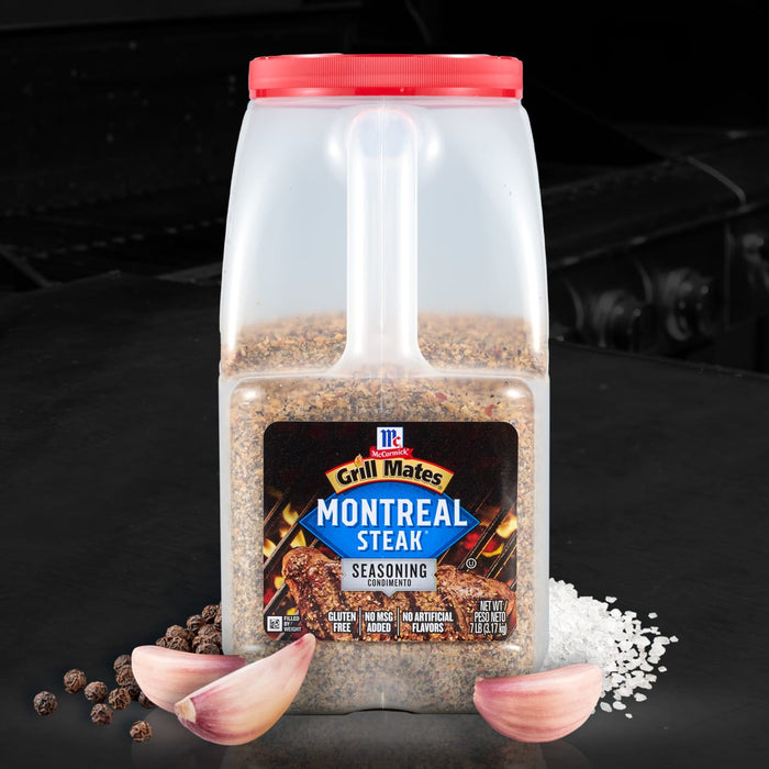 A container of McCormick Montreal Steak Seasoning is displayed with garlic cloves and peppercorns.