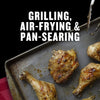 A close-up of grilled, air-fried, and pan-seared chicken pieces on a baking sheet.