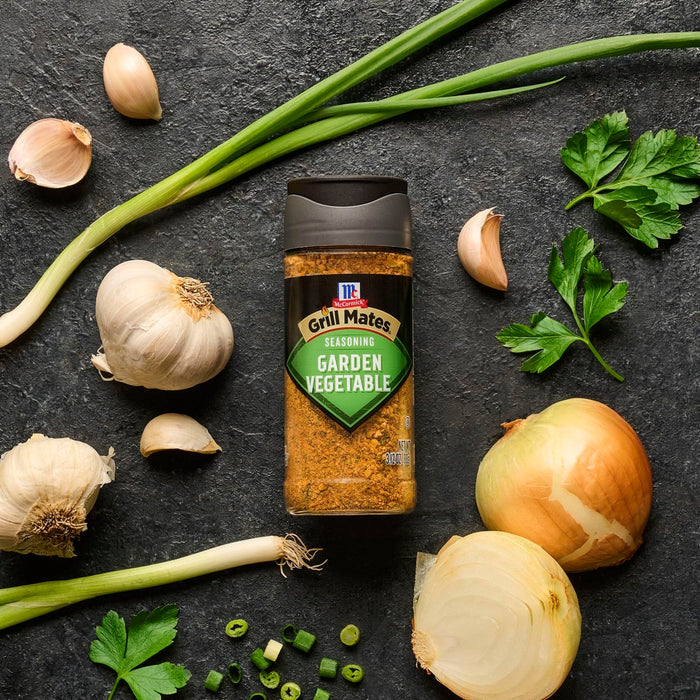 McCormick Garden Vegetable seasoning is displayed with fresh garlic, onions, and herbs, suggesting its use in enhancing the flavor of garden-fresh dishes.