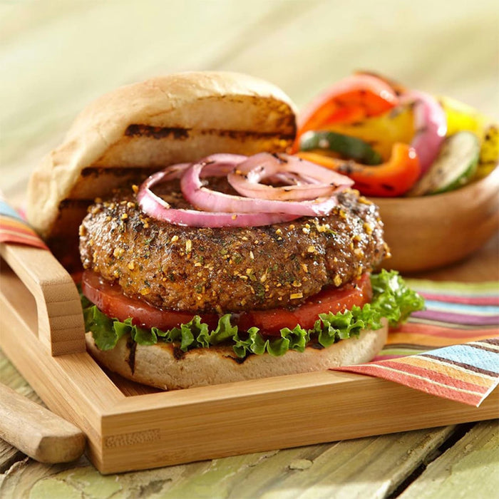 A delicious-looking burger with grilled vegetables on a wooden tray.