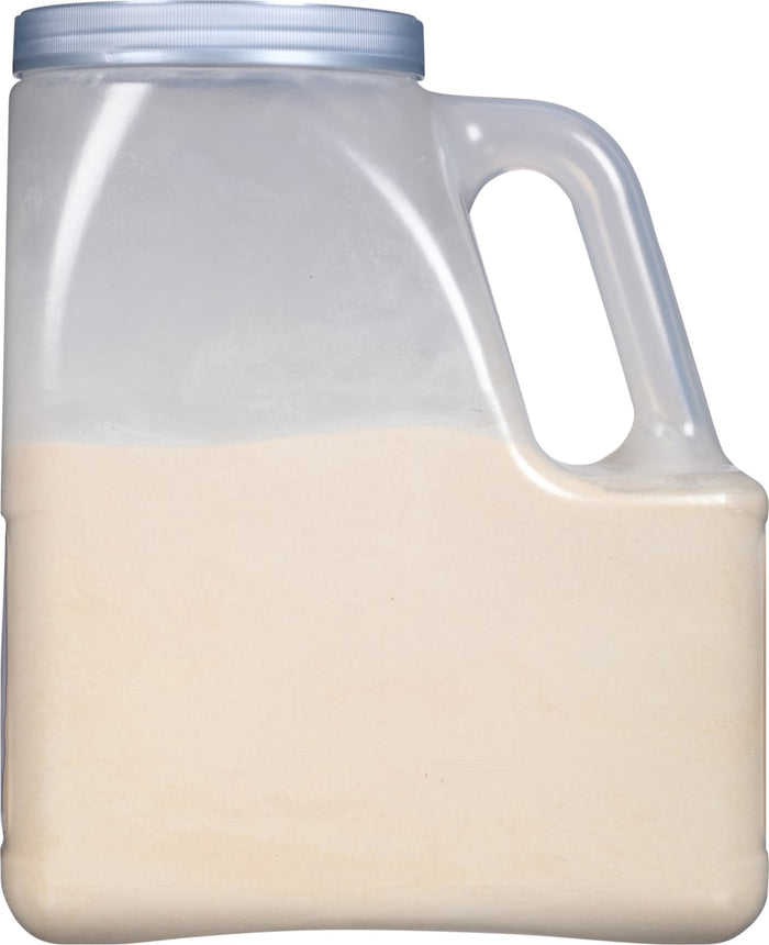 A clear plastic jug with a handle filled with a light beige powder.
