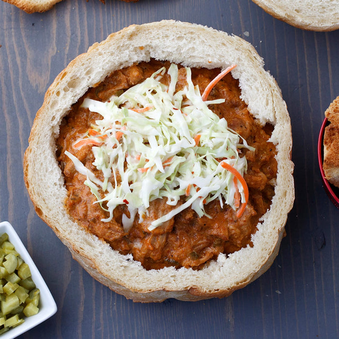 A bunny chow, a South African street food dish, consisting of a hollowed-out loaf of bread filled with curry and topped with coleslaw.