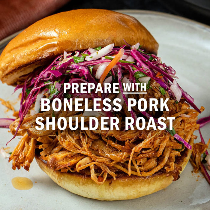 A pulled pork sandwich made with boneless pork shoulder roast is topped with colorful slaw.
