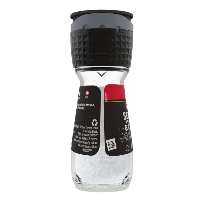 A McCormick Sea Salt grinder with a black top and a clear glass bottom filled with salt.