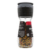 A McCormick Pepper Mill Grinder filled with peppercorns.