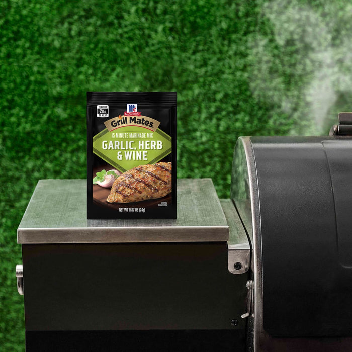 A packet of McCormick Grill Mates Garlic Herb &amp; Wine 15 Minute Marinade Mix is displayed on a grill.