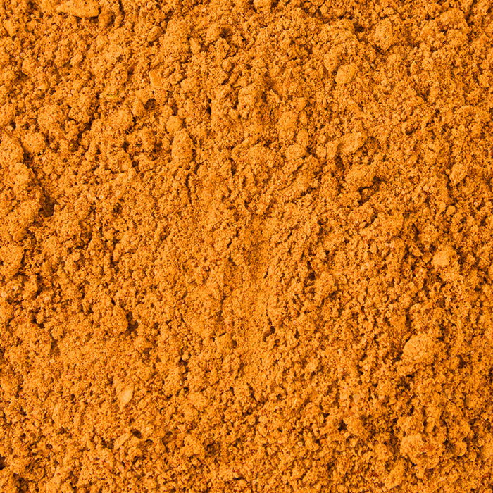 A vibrant orange-brown pile of Mccormick Chicken Taco Seasoning Mix, showcasing its fine, granular texture.
