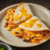 Two quesadillas filled with chicken corn black beans and cheese on a plate.
