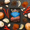 McCormick Grill Mates Montreal Steak seasoning packet surrounded by ingredients like garlic, peppers, and spices.