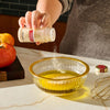 A person is adding McCormick garlic powder to a bowl of olive oil, likely preparing a salad dressing.