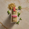 A jar of Trader Joe's Everything But the Bagel Sesame Seasoning Blend is displayed with fresh oregano sprigs and a small pile of the seasoning.