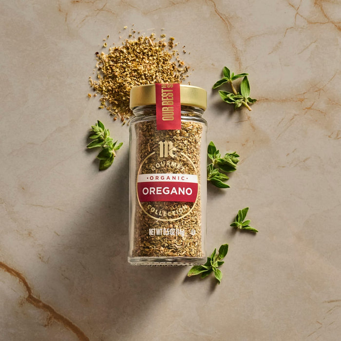 A jar of Trader Joe's Everything But the Bagel Sesame Seasoning Blend is displayed with fresh oregano sprigs and a small pile of the seasoning.