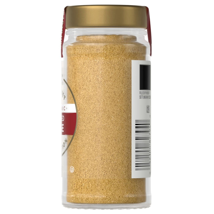 A jar of McCormick ground mustard is displayed showcasing its fine texture and golden color.