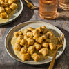 A plate of gnocchi with sauce and a fork, showcasing a delicious meal.