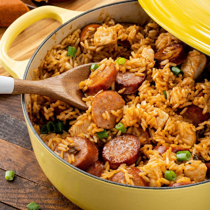 A yellow pot filled with jambalaya a Cajun and Creole dish made with rice chicken sausage and vegetables.