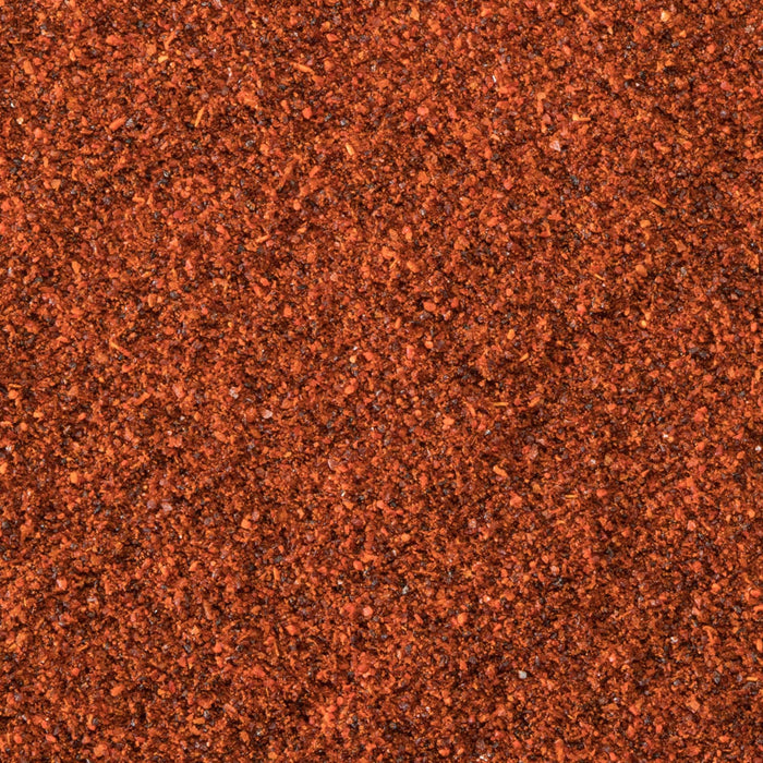 A textured surface with a consistent reddish-brown color, resembling fine granules or sand.