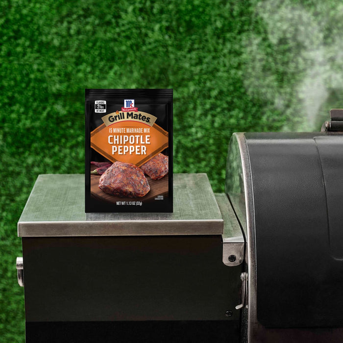 A packet of McCormick Grill Mates Chipotle Pepper seasoning sits on a grill.