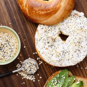 A close-up of a bagel with cream cheese and everything bagel seasoning.