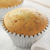 A close-up of a poppy seed muffin in a silver cupcake liner.