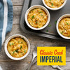 Four ramekins of classic crab imperial seasoned with Old Bay Regular Crab Cake Seasoning Mix 1.24 Oz are garnished with fresh parsley on a rustic wooden table.