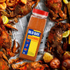 A bottle of Old Bay Seasoning sits on a table with a spread of crab legs, potatoes, and lemons.
