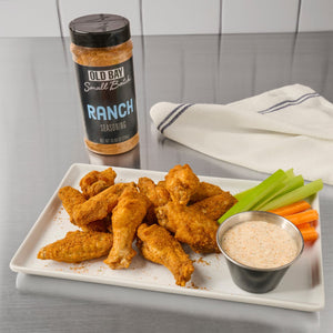 A plate of chicken wings seasoned with Old Bay Small Batch Ranch Seasoning served with celery carrots and dipping sauce.