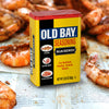 A can of Old Bay Blackened Seasoning is displayed against a backdrop of seasoned shrimp.