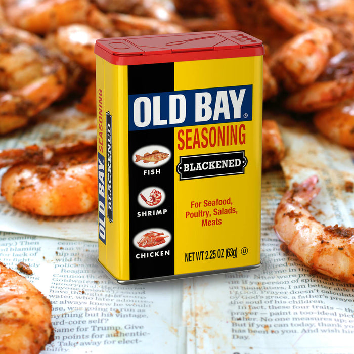 A can of Old Bay Blackened Seasoning is displayed against a backdrop of seasoned shrimp.