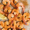 A close-up of seasoned shrimp with a lemon wedge, showcasing a flavorful seafood dish.