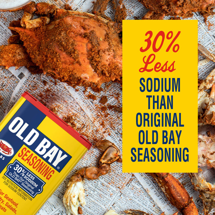 A can of Old Bay Seasoning with 30% less sodium is displayed alongside cooked crabs seasoned with the product.